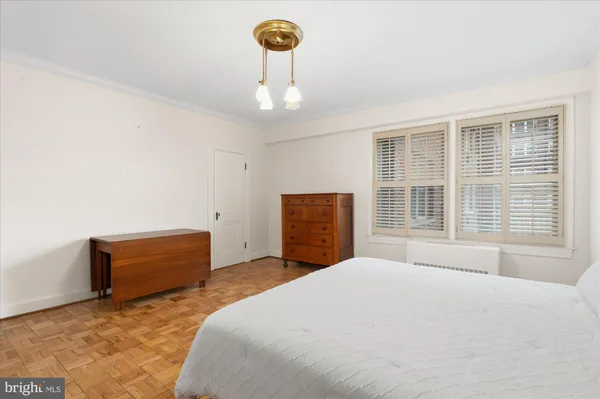 a bedroom with a bed dresser and a window