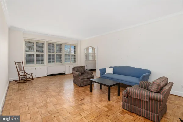 a living room with couches and dining table with wooden floor
