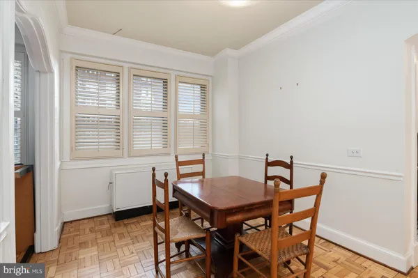 a view of a dining room with furniture and a refrigerator