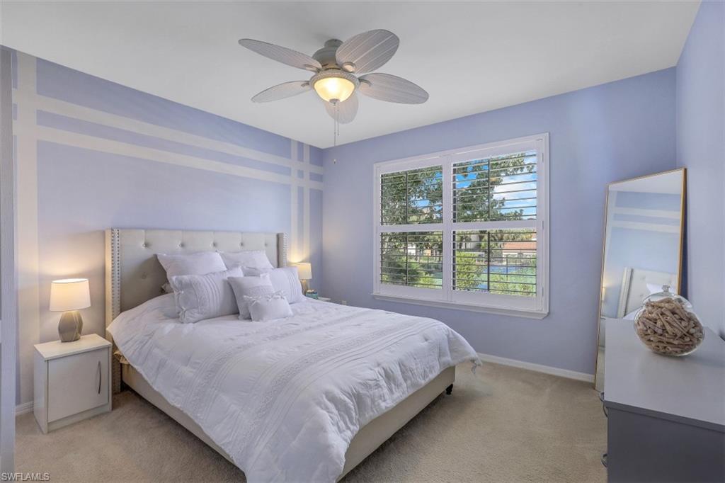 13621 Eagle Ridge Drive, Unit 1522 Fort Myers, FL 33912 - Photo 12 of 22 a bedroom with a large bed and a chandelier