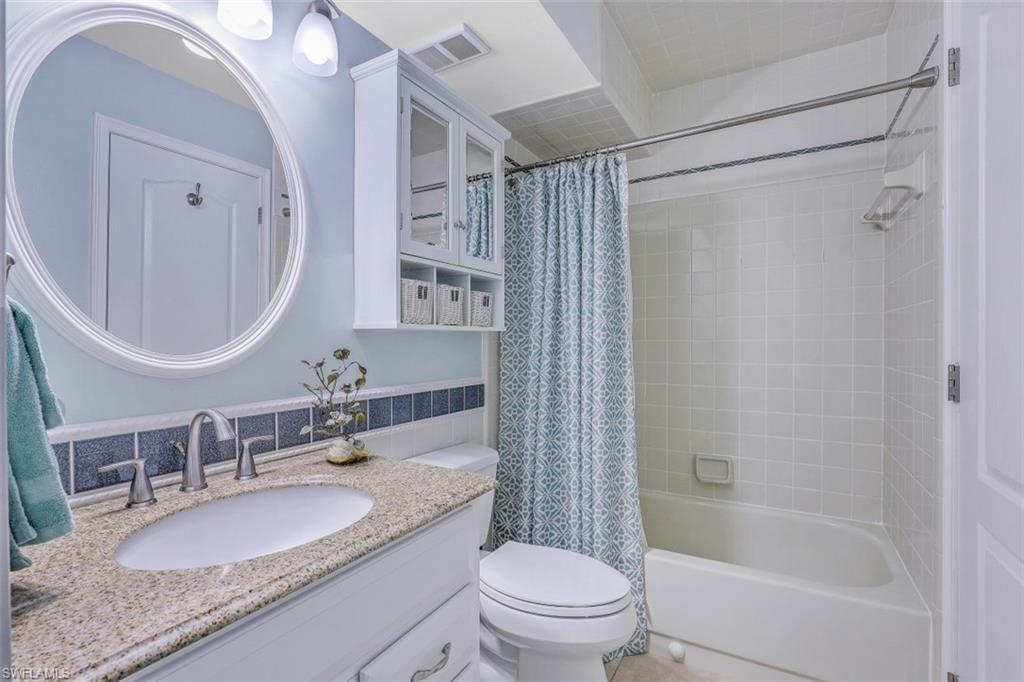 13621 Eagle Ridge Drive, Unit 1522 Fort Myers, FL 33912 - Photo 13 of 22 a bathroom with a granite countertop sink toilet mirror and shower