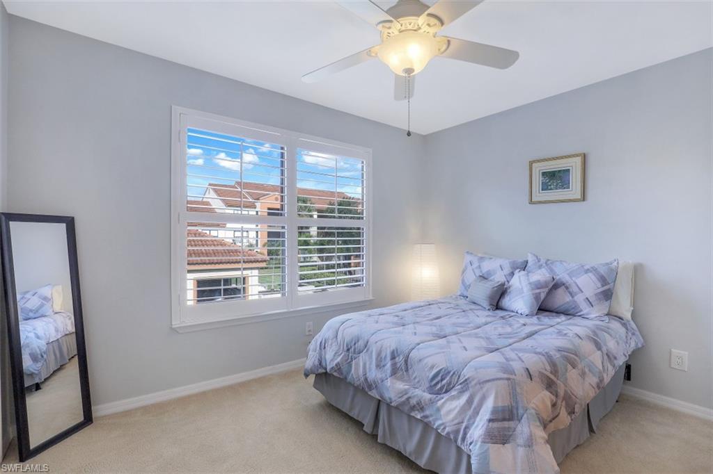 13621 Eagle Ridge Drive, Unit 1522 Fort Myers, FL 33912 - Photo 16 of 22 a bedroom with a large bed and a chandelier