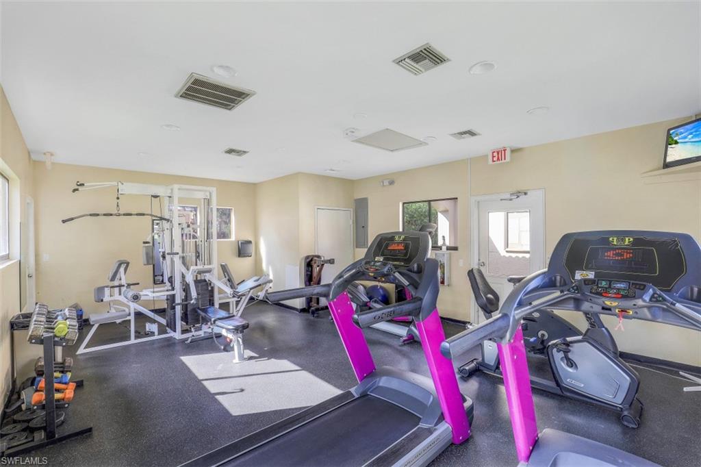 13621 Eagle Ridge Drive, Unit 1522 Fort Myers, FL 33912 - Photo 19 of 22 a living room with lots of furniture and gym equipment