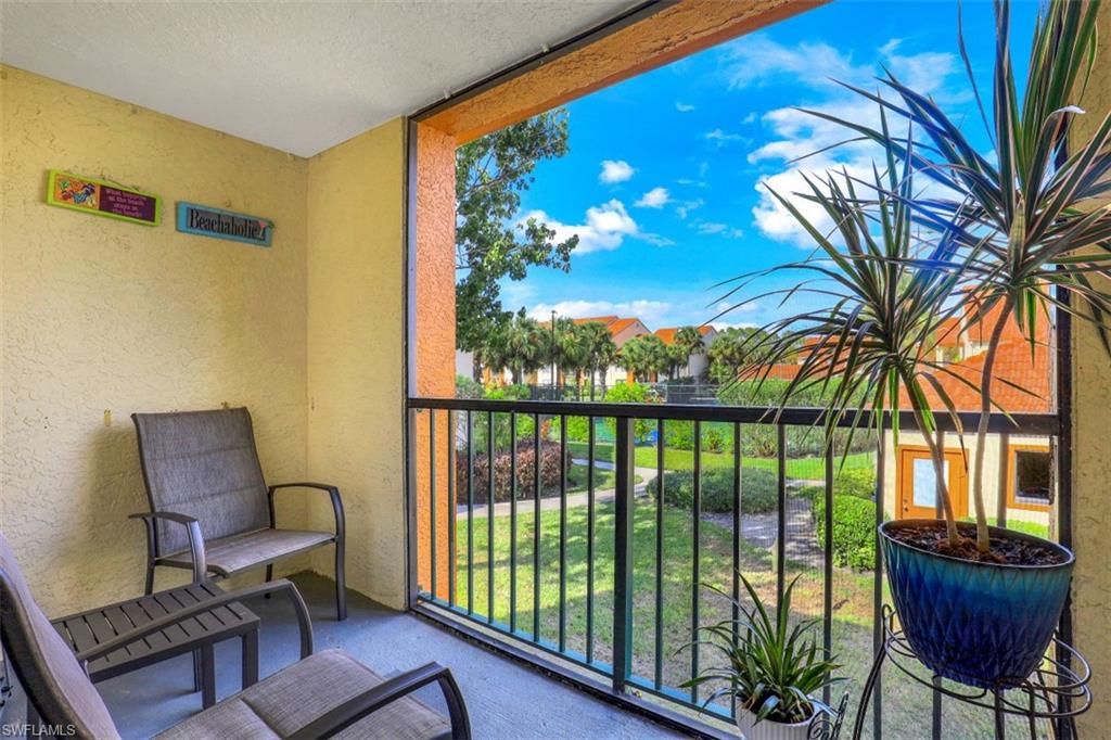 13621 Eagle Ridge Drive, Unit 1522 Fort Myers, FL 33912 - Photo 7 of 22 a living room with furniture and a floor to ceiling window