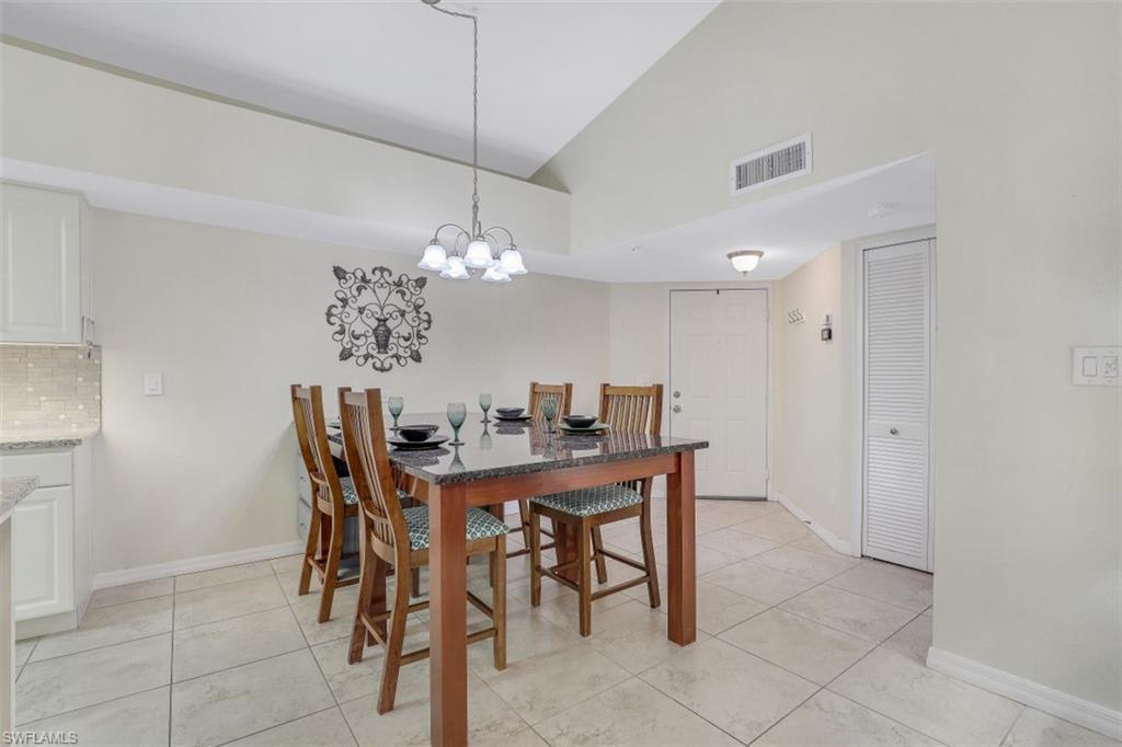 13621 Eagle Ridge Drive, Unit 1522 Fort Myers, FL 33912 - Photo 8 of 22 a view of a dining room with furniture and chandelier