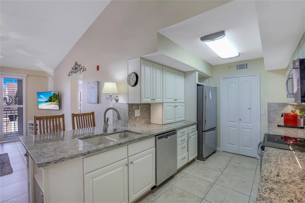 13621 Eagle Ridge Drive, Unit 1522 Fort Myers, FL 33912 - Photo 9 of 22 a kitchen with stainless steel appliances granite countertop a sink and a refrigerator