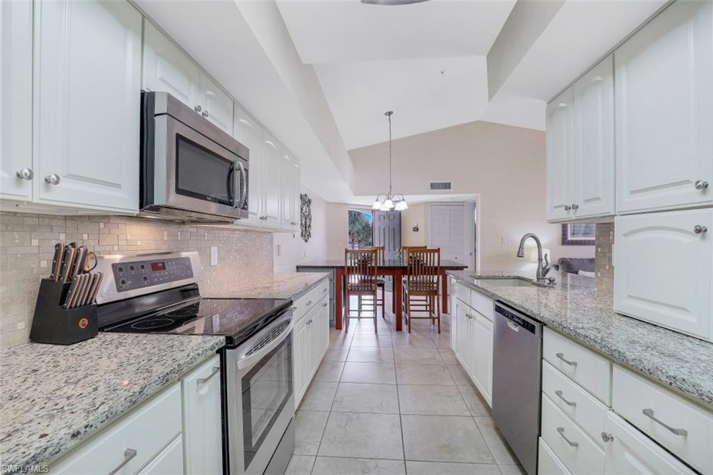 13621 Eagle Ridge Drive, Unit 1522 Fort Myers, FL 33912 - Photo 10 of 22 a kitchen with granite countertop sink stainless steel appliances and white cabinets