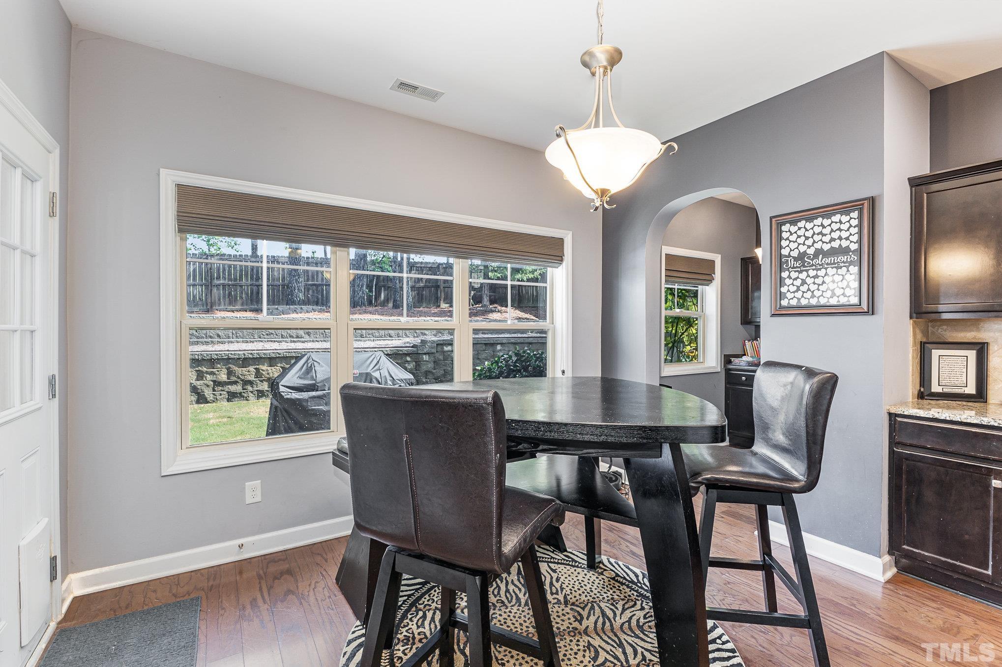 1604 Hauser Lake Road Knightdale, NC 27545 - Photo 11 of 32 a dining room with furniture a chandelier and wooden floor