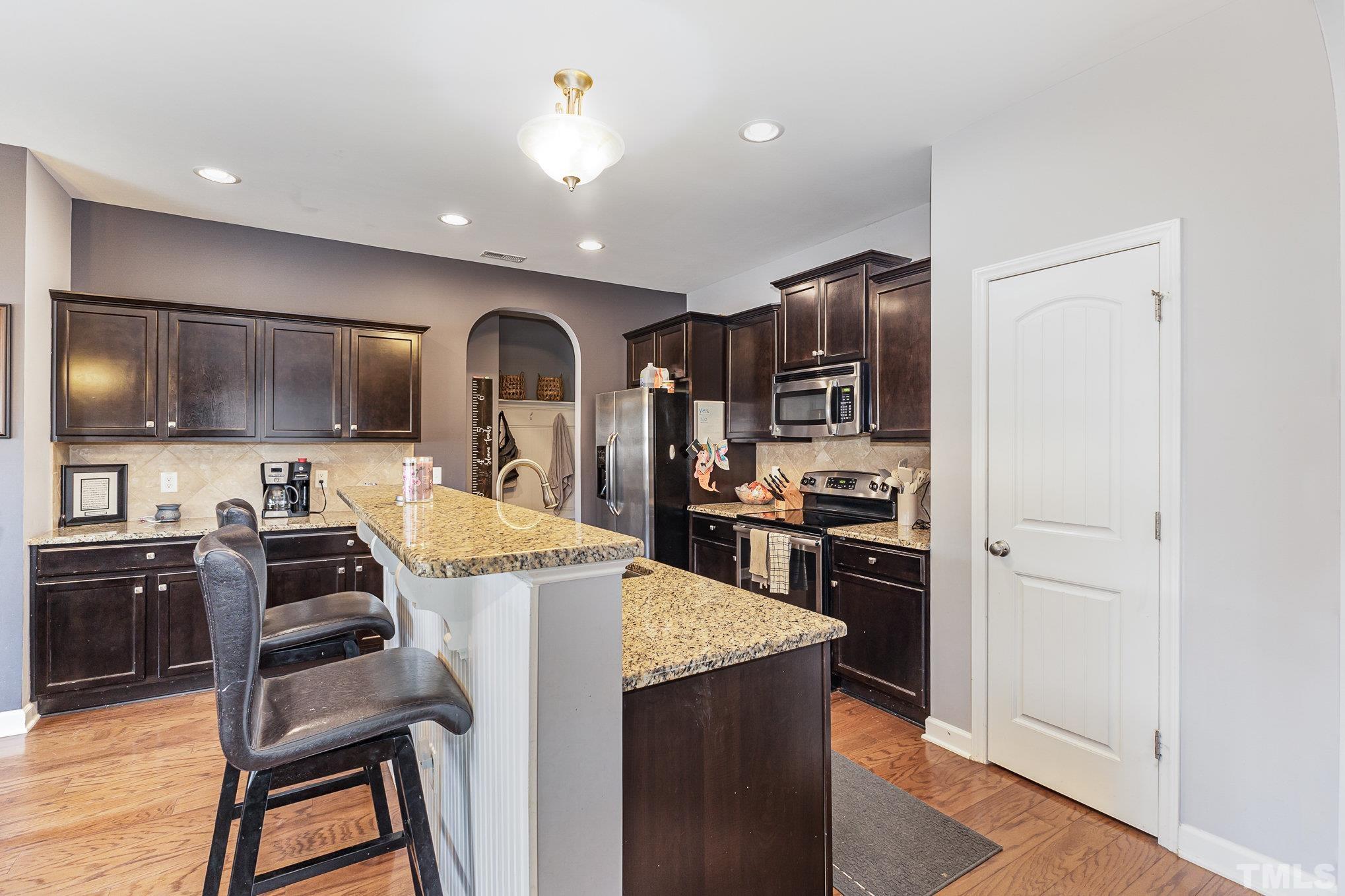 1604 Hauser Lake Road Knightdale, NC 27545 - Photo 13 of 32 a kitchen with kitchen island a stove a sink and a refrigerator