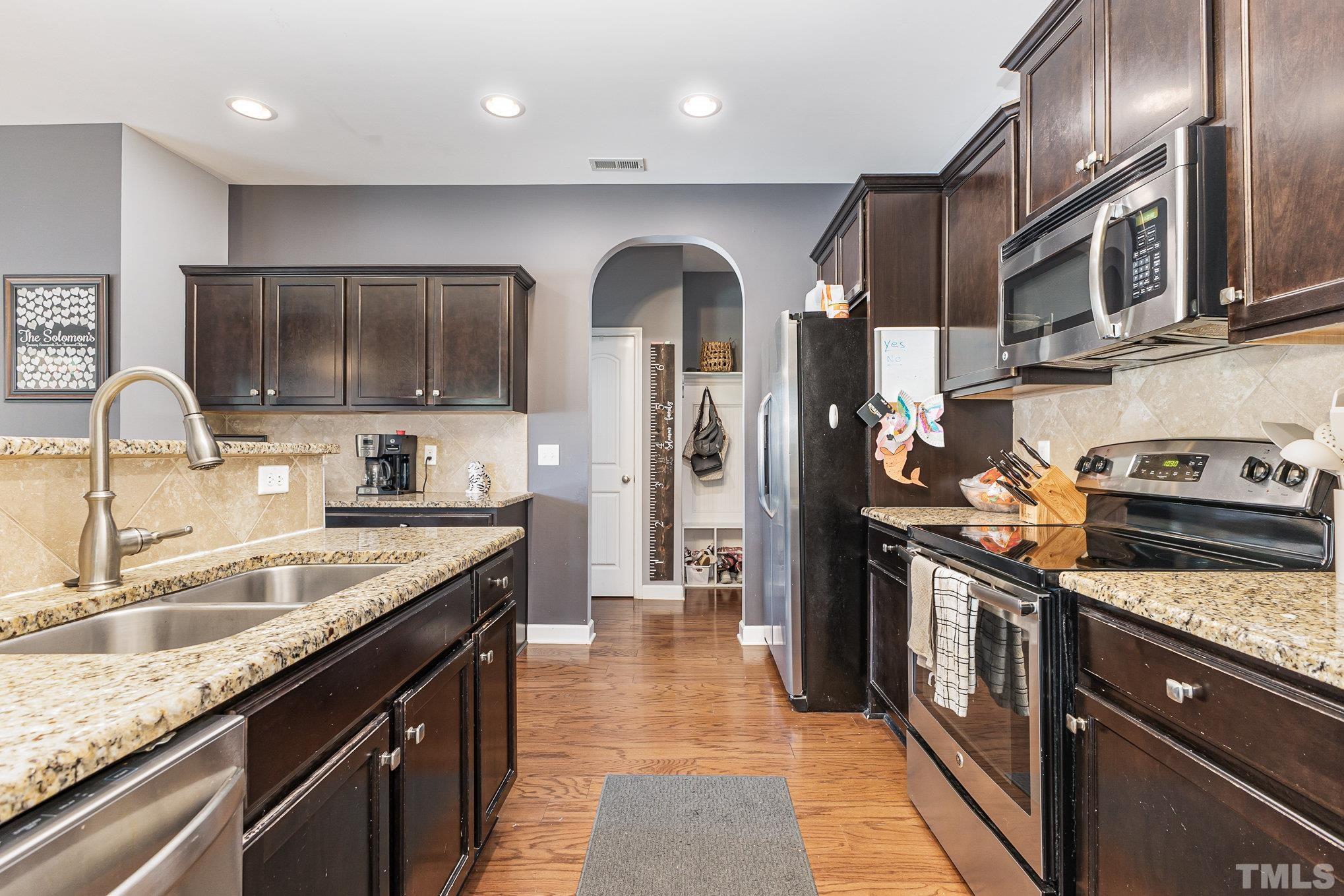 1604 Hauser Lake Road Knightdale, NC 27545 - Photo 14 of 32 a kitchen with stainless steel appliances granite countertop a sink a stove and a refrigerator