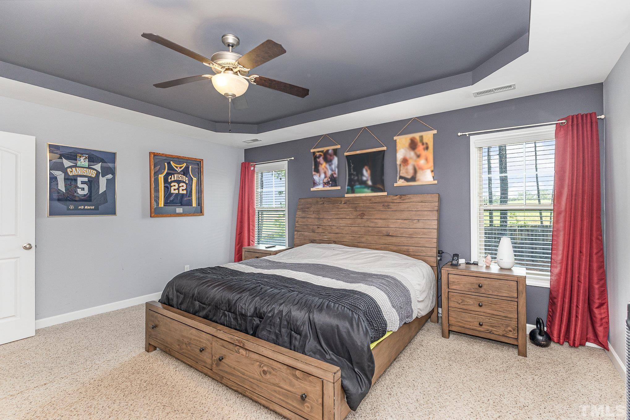1604 Hauser Lake Road Knightdale, NC 27545 - Photo 19 of 32 a bedroom with a large bed and a chandelier
