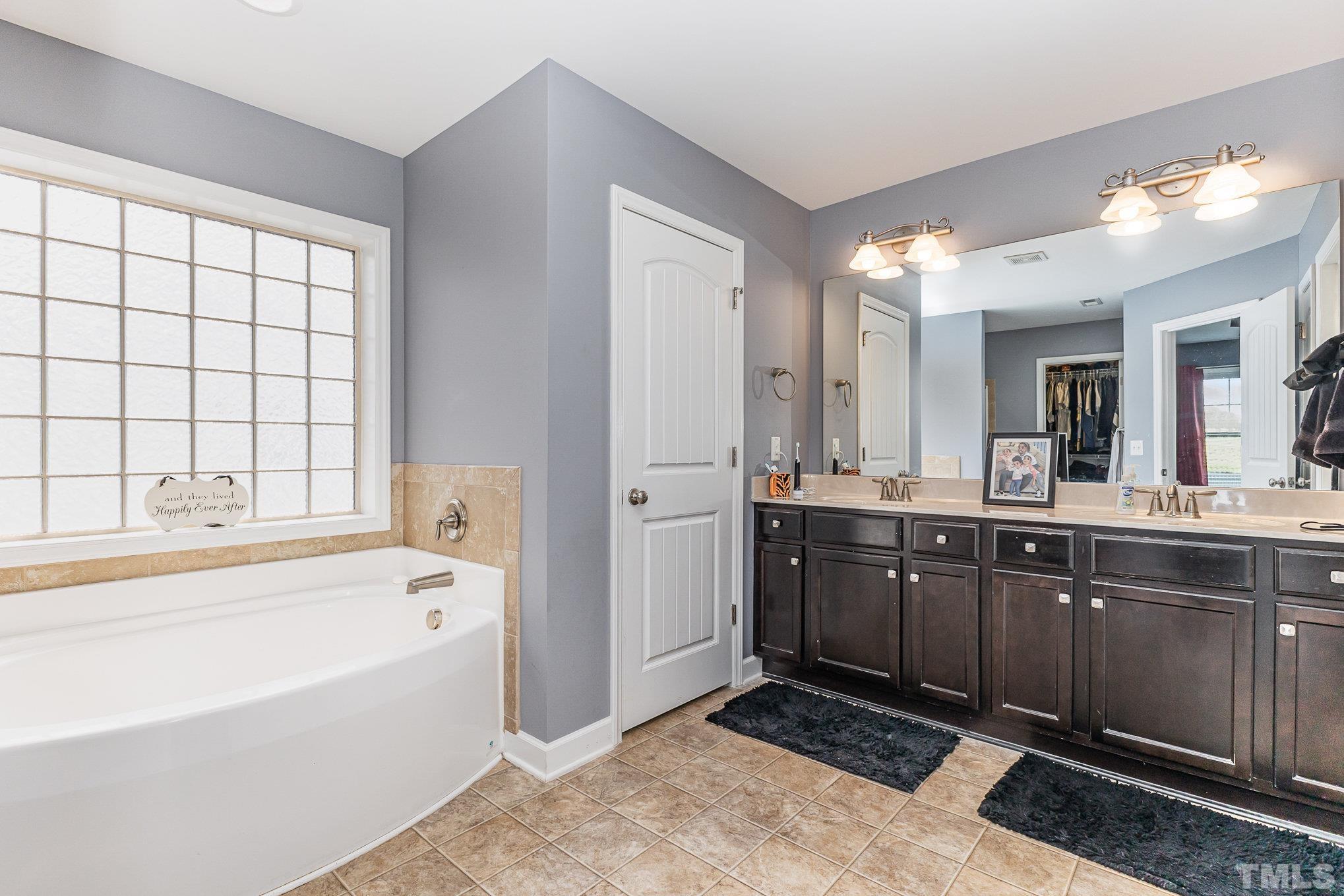 1604 Hauser Lake Road Knightdale, NC 27545 - Photo 20 of 32 a spacious bathroom with a tub sink and mirror