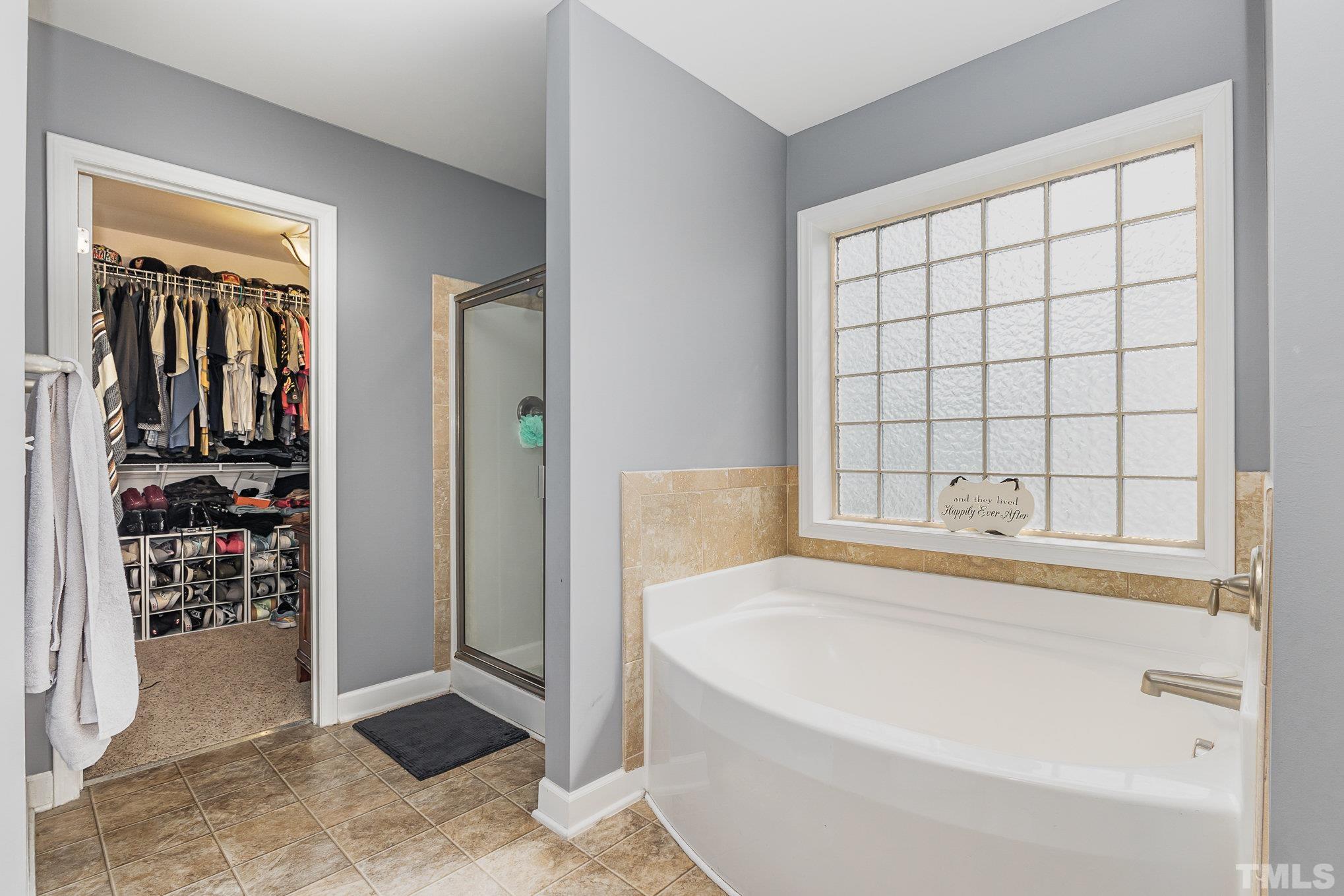 1604 Hauser Lake Road Knightdale, NC 27545 - Photo 21 of 32 a spacious bathroom with a bathtub and next to a window
