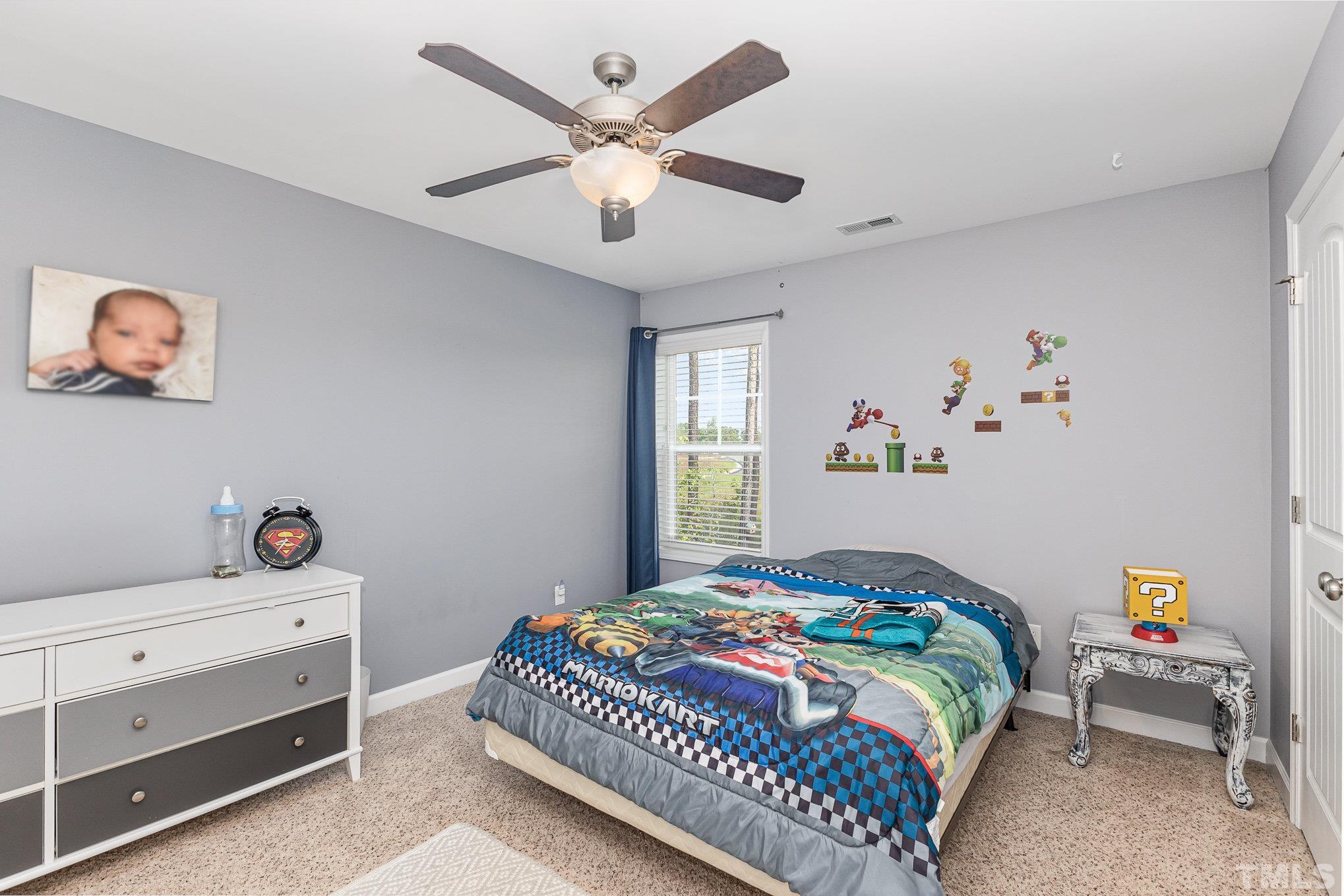 1604 Hauser Lake Road Knightdale, NC 27545 - Photo 22 of 32 a bedroom with a bed and a chandelier