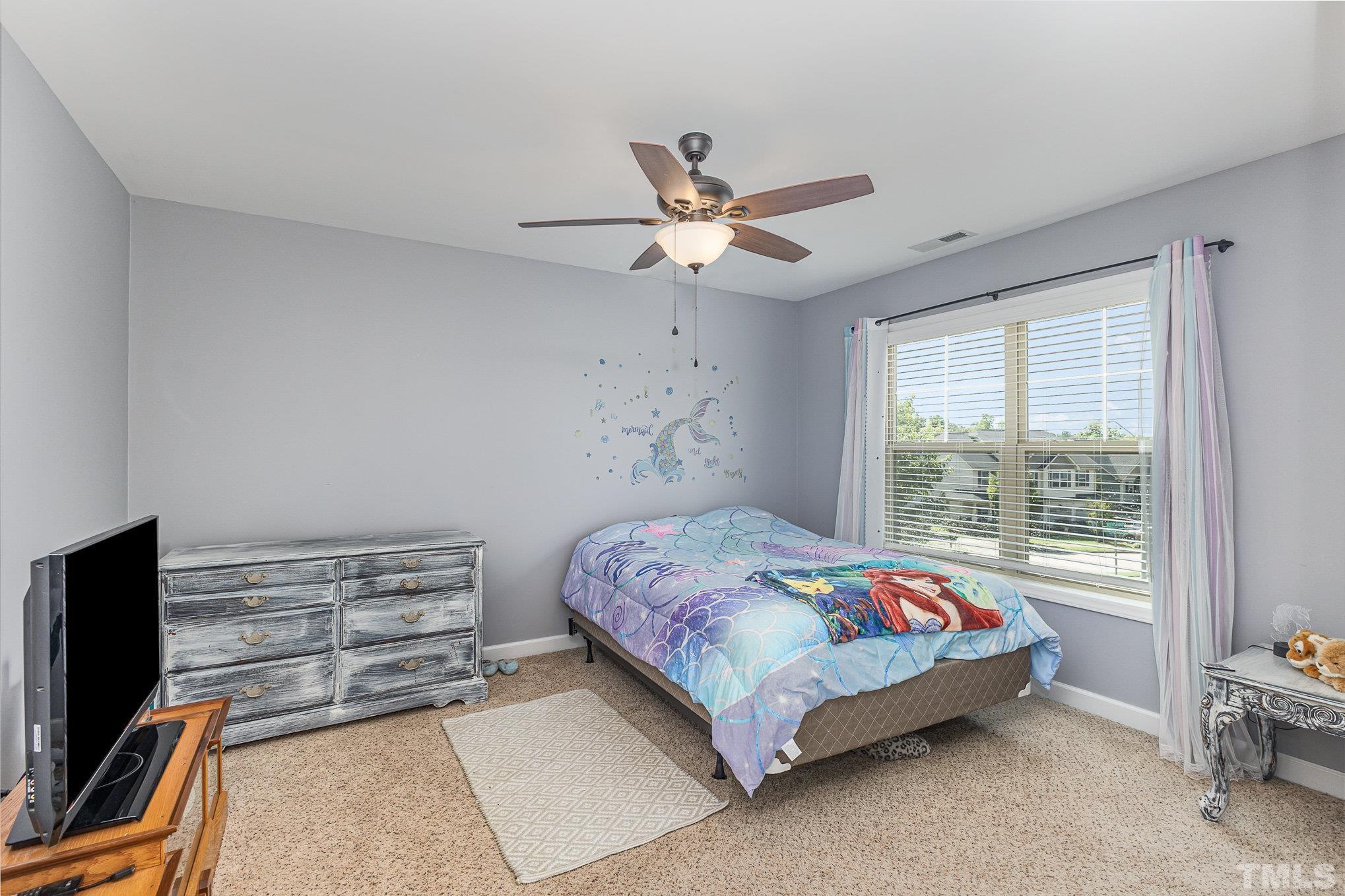 1604 Hauser Lake Road Knightdale, NC 27545 - Photo 24 of 32 a bedroom with a bed and a chandelier