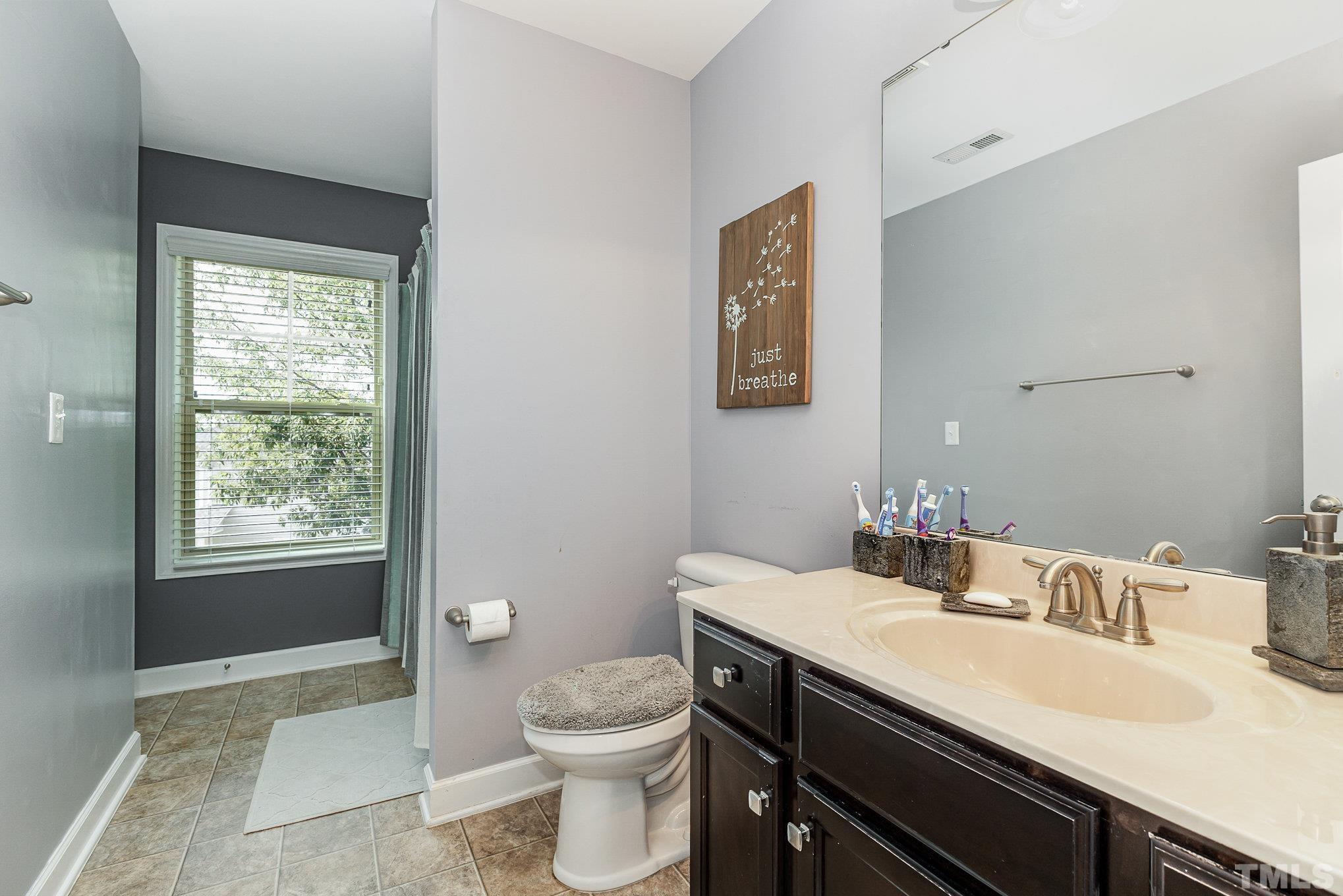 1604 Hauser Lake Road Knightdale, NC 27545 - Photo 25 of 32 a bathroom with a granite countertop sink toilet and a mirror