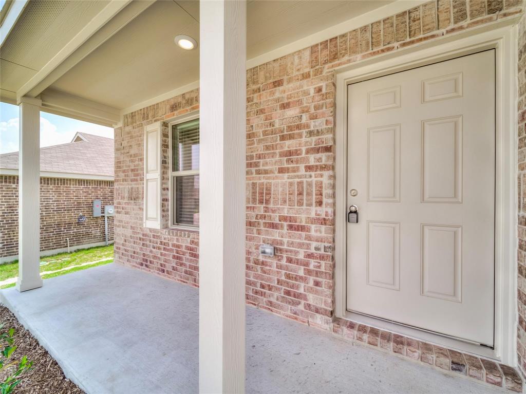 357 Sun Bluff Road Fort Worth, TX 76052 - Photo 3 of 35 Covered front porch featuring a multi-toned brick facade, white paneled entry door, white support columns, and recessed lighting