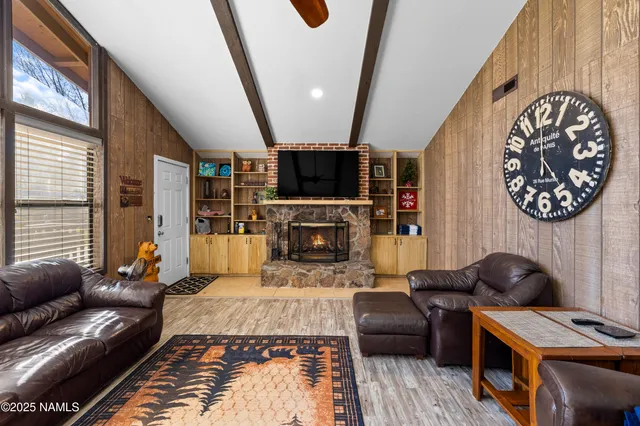 a living room with furniture a flat screen tv and a fireplace