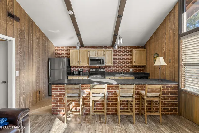 a kitchen with stainless steel appliances kitchen island granite countertop a refrigerator and microwave