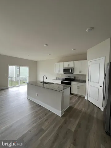 a kitchen with stainless steel appliances a refrigerator sink and white cabinets