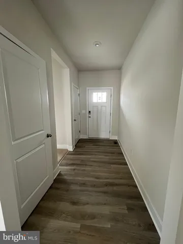 a view of a hallway with wooden floor and closet