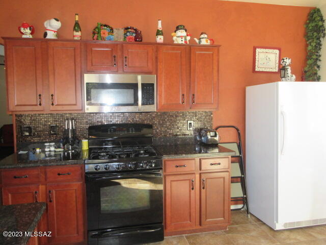511 Camino Hombre De Oro Rio Rico, AZ 85648 - Photo 27 of 44 a kitchen with stainless steel appliances granite countertop a stove a sink and a microwave