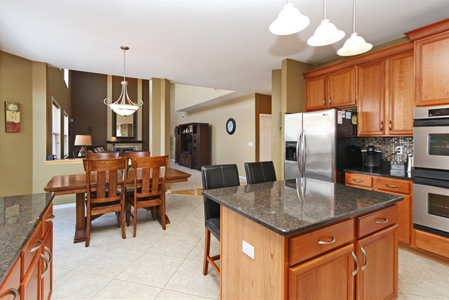 1561 Southgate Road Bartlett, IL 60103 - Photo 4 of 25 a kitchen with stainless steel appliances granite countertop a kitchen island a table and chairs