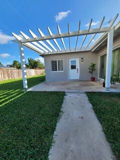 1351 West Mango Street, Unit A Lantana, FL 33462 - Photo 4 of 5 a backyard of a house with table and chairs