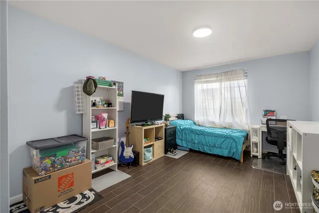 a bedroom with furniture and a wooden floor