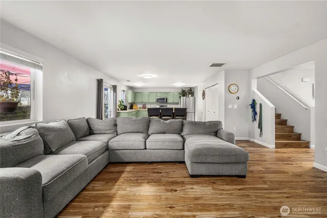 a kitchen with stainless steel appliances kitchen island granite countertop a table chairs stove and refrigerator