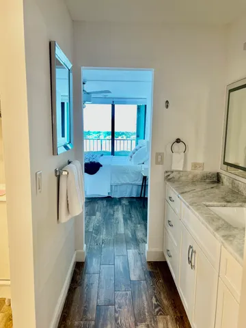 a large white bed sitting in a bedroom next to a window