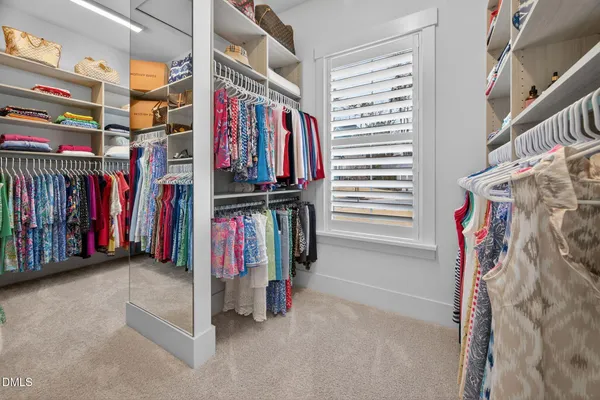 a view of walk in closet with clothes and shoes