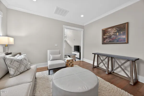 a living room with furniture a flat screen tv and kitchen view