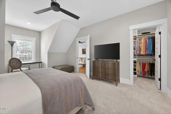 a view of a white house with a big yard and potted plants