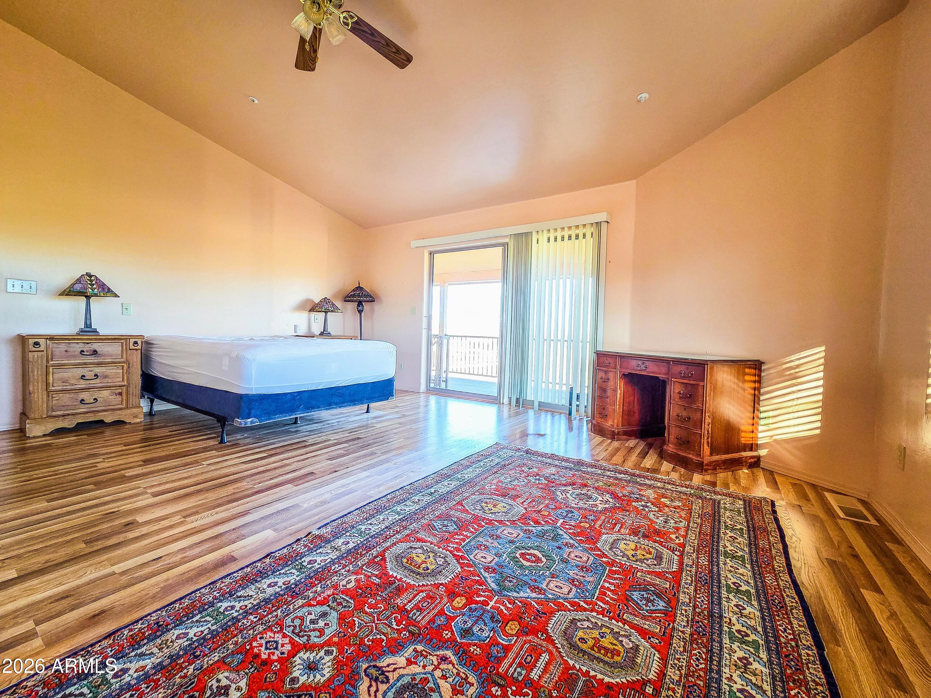 14350 East Meadow Ranch Place Dewey, AZ 86327 - Photo 19 of 54 a bedroom with a bed and wooden floor