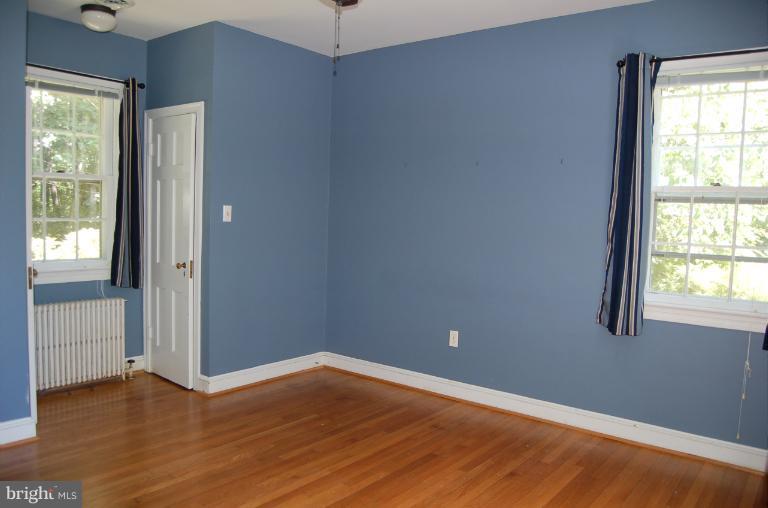 1010 Ashton Road Ashton, MD 20861 - Photo 9 of 12 an empty room with wooden floor and windows