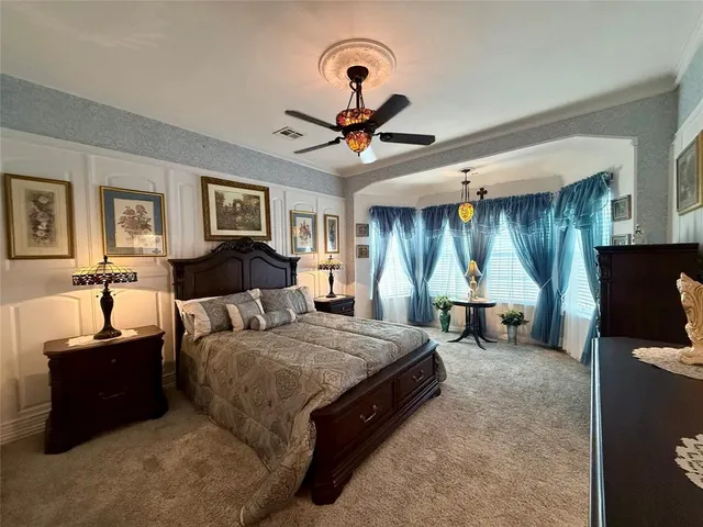 a spacious bedroom with a bed and a chandelier
