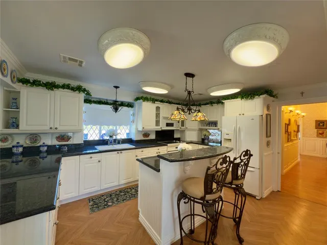 a kitchen with stainless steel appliances granite countertop a sink a stove and a refrigerator