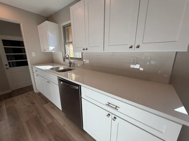 a kitchen with granite countertop a sink a stove and cabinets