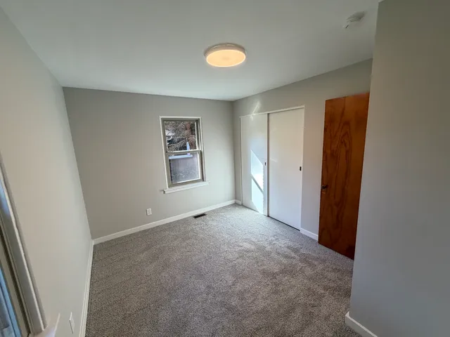 an empty room with windows and closet