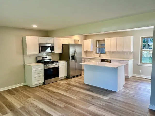 a large kitchen with a refrigerator and a stove top oven
