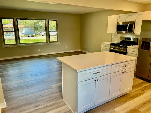 a kitchen with a sink cabinets and wooden floor