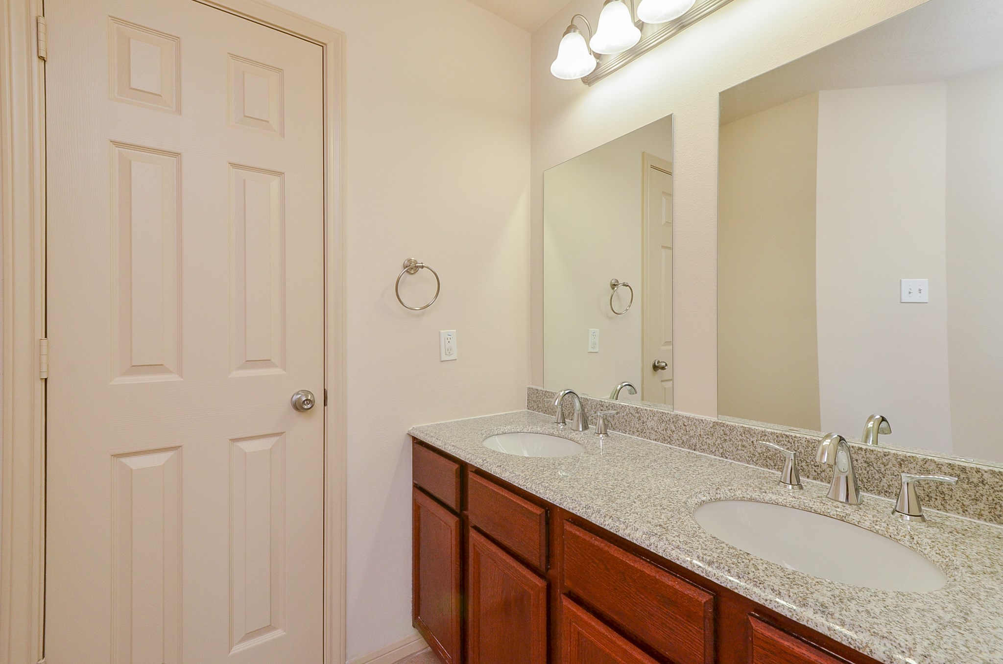 25135 Ginger Ranch Drive Katy, TX 77494 - Photo 22 of 32 Primary bath: Dual granite vanities with framed mirrors and updated lighting provide a clean, functional layout with ample storage.
