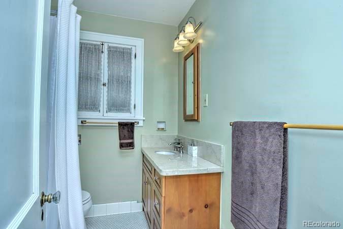 2536 Glencoe Street Denver, CO 80207 - Photo 13 of 26 a bathroom with a sink a mirror and a shower