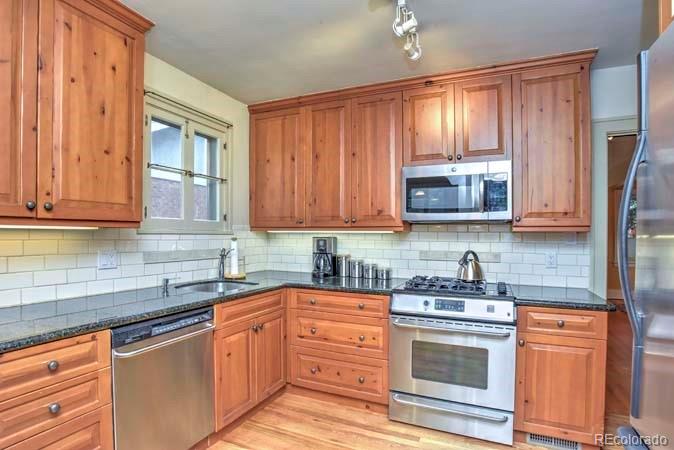 2536 Glencoe Street Denver, CO 80207 - Photo 6 of 26 a kitchen with stainless steel appliances granite countertop a stove a sink dishwasher and a microwave oven with cabinets