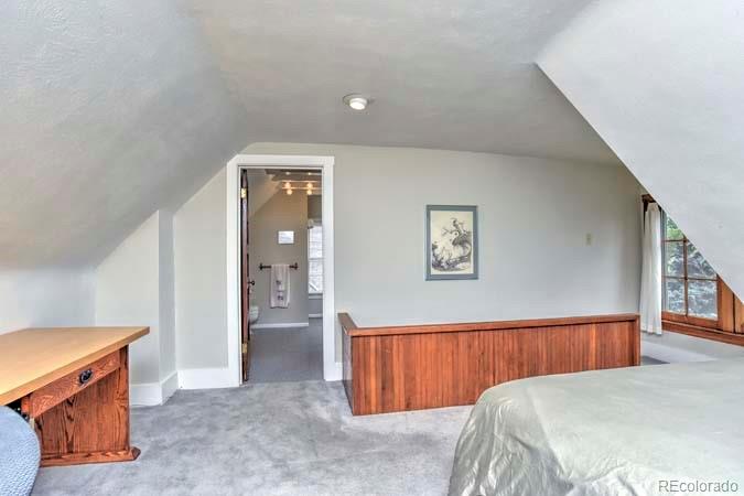 2536 Glencoe Street Denver, CO 80207 - Photo 9 of 26 a bedroom with a bed and a dresser with rug