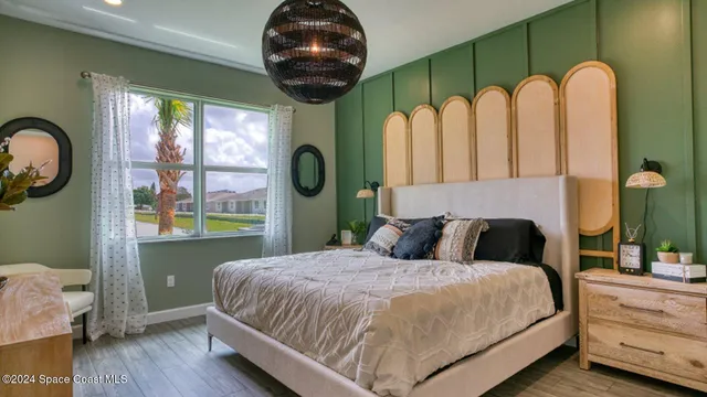 a bedroom with a large bed and a potted plant