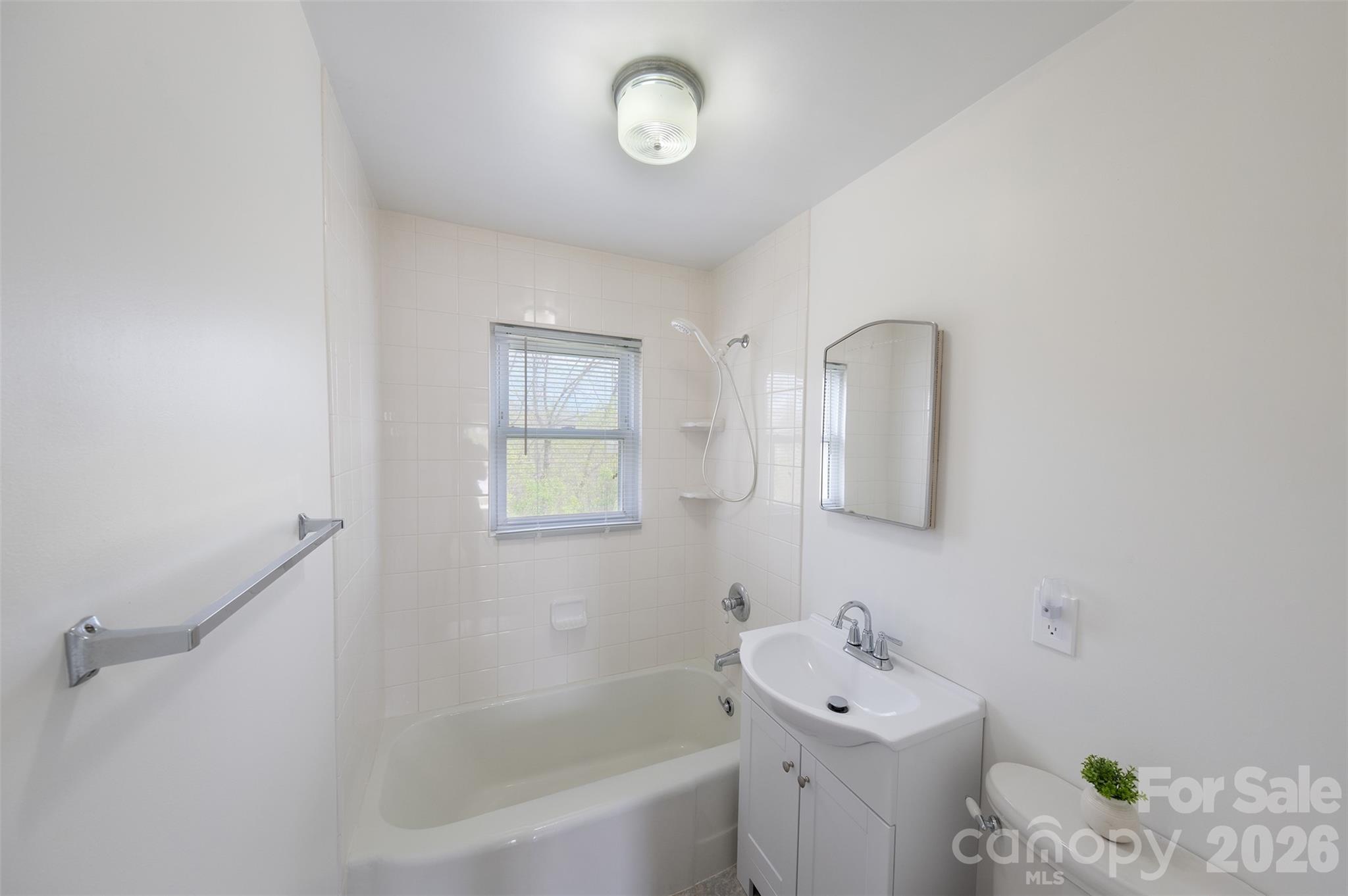 166 Spruce Street Canton, NC 28716 - Photo 12 of 23 a bathroom with a bathtub sink vanity and mirror