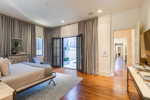 a spacious bedroom with a large bed and a flat tv screen