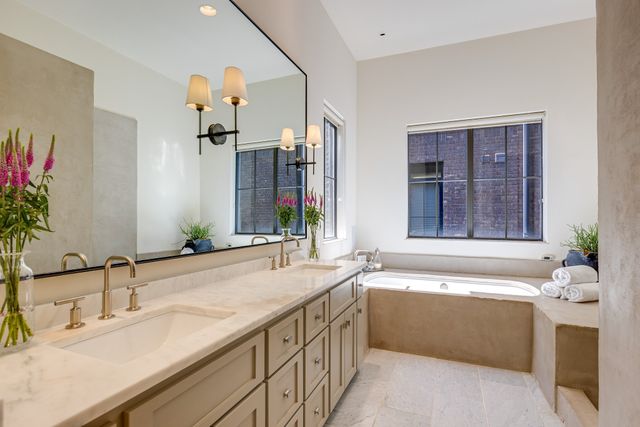 a bathroom with a granite countertop sink a mirror and a bathtub